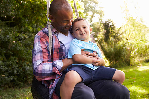 istock Father And Son Having Fun On Tire Swing In Garden 613765854