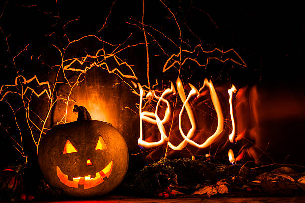 istock Spooky halloween pumpkin background with light draw BOO 613767154