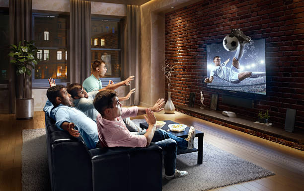 istock Students watching very realistic Soccer game on TV 613767824