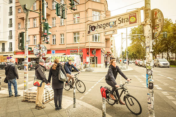 Everyday life in Berlin with bikers and pedestrians moving around Berlin, Germany - October 7, 2016: motion view of everyday life with bikers and pedestrians at beginning of Box Hagener Strasse in the area of Friedrichshain in a standard grey autumn day friedrichshain photos stock pictures, royalty-free photos & images