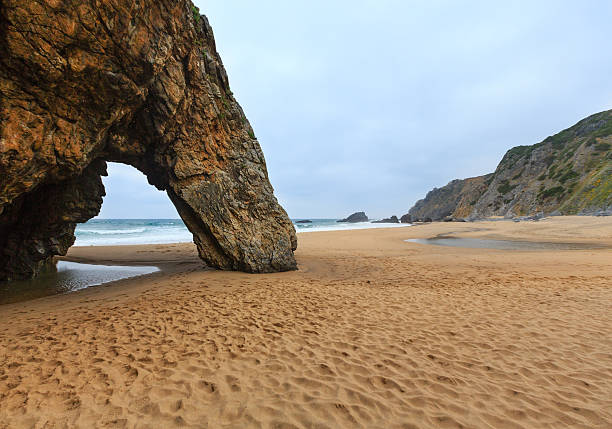 Atlantic ocean coast view (sea cliffs and beach) in cloudy weather near Cape Roca (Cabo da Roca), Portugal.