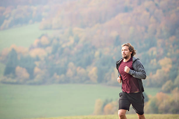 istock Handsome young man running in sunny autumn nature. 613770208