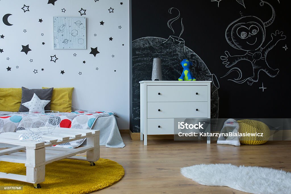 Change child room into an outer space Child room in contemporary style with blackboard wall, stars on the wall and simple furniture Child Stock Photo