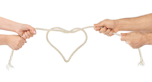 istock Man and woman hands with heart shaped rope 613772446
