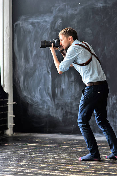 istock photographer working in photostudio with camera in hands 613772926