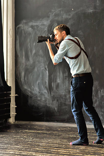 istock photographer working in photostudio with camera in hands 613772966