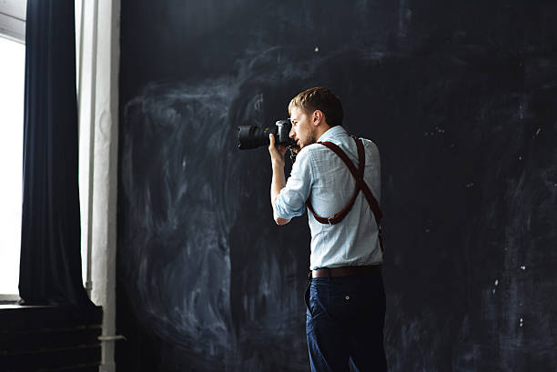 istock photographer working in photostudio with camera in hands 613772990