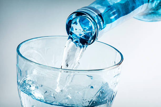 istock Pouring water on glass on white background 613773862