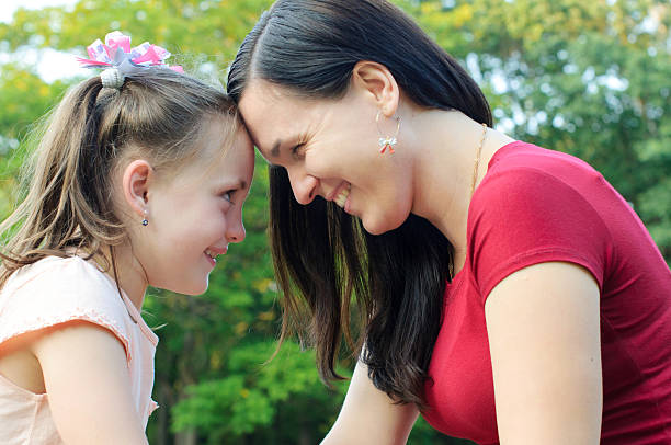 istock Mother with daughter having fun in the park 613775300