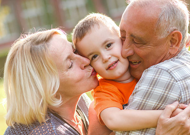 felice nonno con nipote che abbraccia - grandfather adult affectionate little boys foto e immagini stock