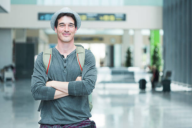 istock Young traveler similing at camera in departure terminal. 613776506