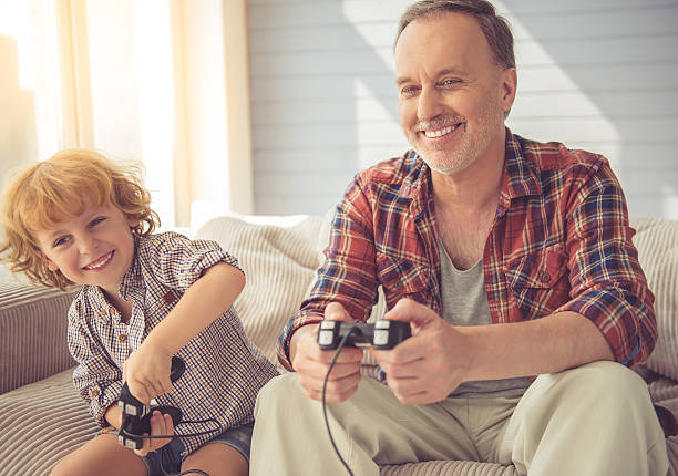 grandpa y nieto - video game child handheld video game little boys fotografías e imágenes de stock