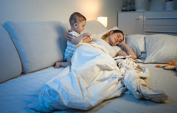 istock Mother trying to sleep while her baby waking her up 613781200