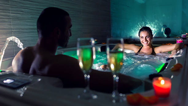 casal na piscina de hidromassagem - couple hot tub spa treatment health spa - fotografias e filmes do acervo