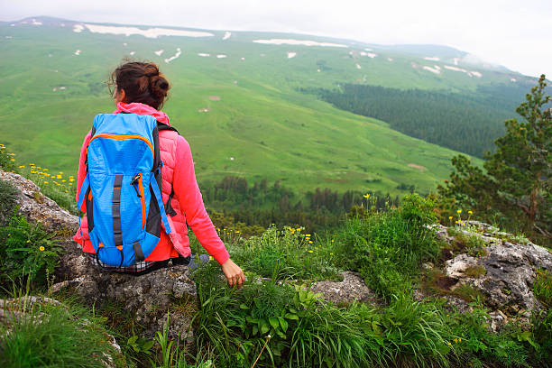 istock Hiker with backpack relaxing on top of mountain 613782300