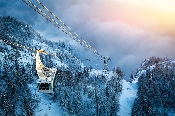Cable car above the fog on the way to the top of the ski slope.