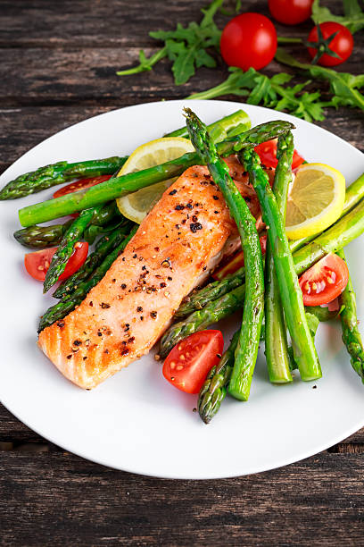 istock Fried salmon with asparagus, tomatoes, lemon, yellow lime on white 613783094