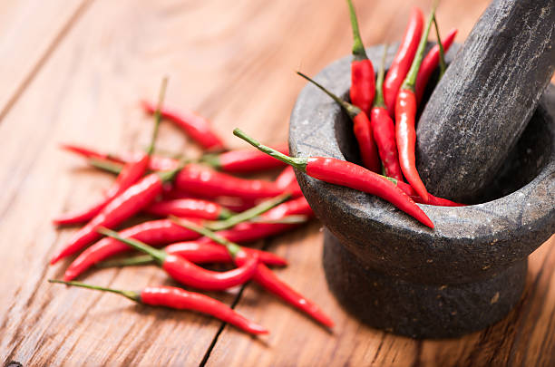 istock Closeup Chillies in Mortar on wood table 613783434