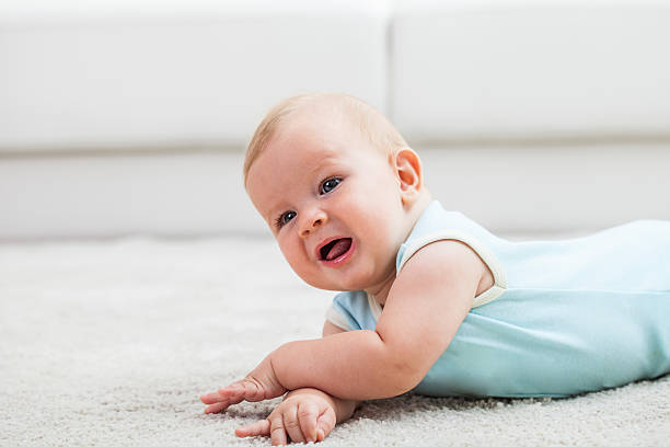 istock Baby boy lying down on a carpet 613783764