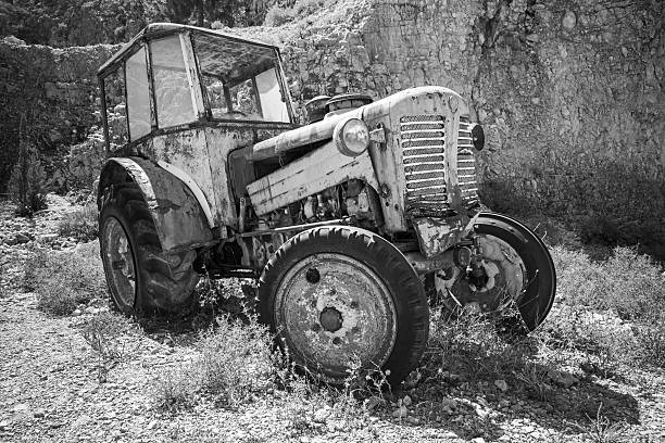 istock Old abandoned rusted tractor stands on grass 613783900
