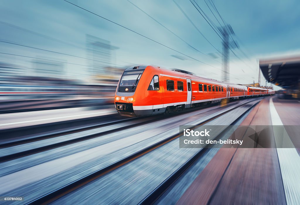 Modern high speed red passenger commuter train. Railway station Modern high speed red passenger commuter train in motion at the railway platform. Railway station. Railroad with motion blur effect. Industrial concept landscape with instagram toning. Transportation Train - Vehicle Stock Photo