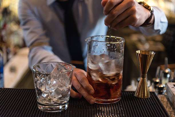 istock Bartender in formal dress serving cocktail drinks 613784708