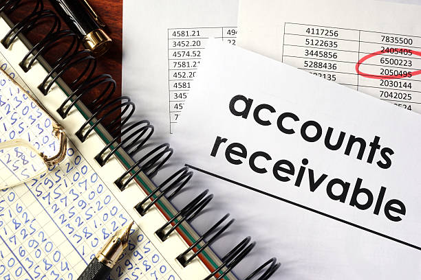 istock Open book with figures and paper with words  accounts receivable. 613785056