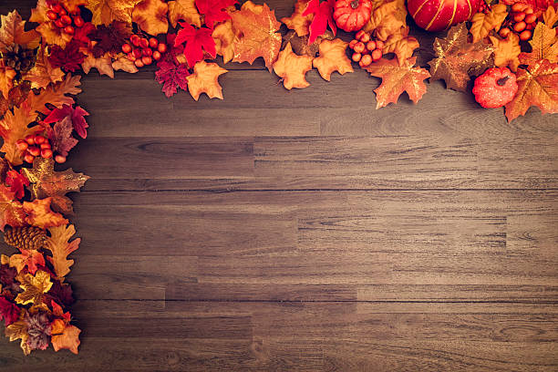 istock Leafs on Wooden Autumn Decoration Background 613785836
