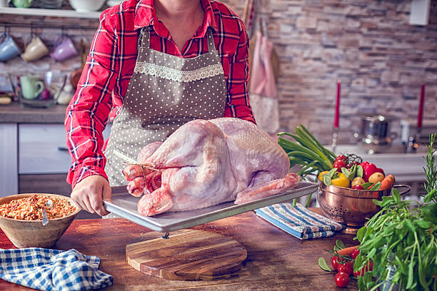 istock Preparing Stuffed Turkey with Vegetables for Holiday Dinner 613787054