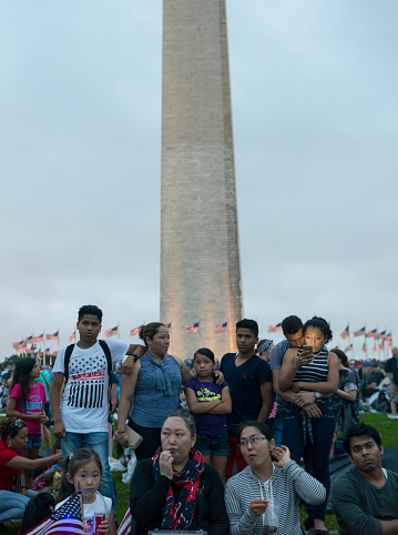 Washington DC, USA - July 4, 2016: People of various ethnicities gather on the National Mall in Washington DC to watch the Fourth of July fireworks display set for later in the evening.