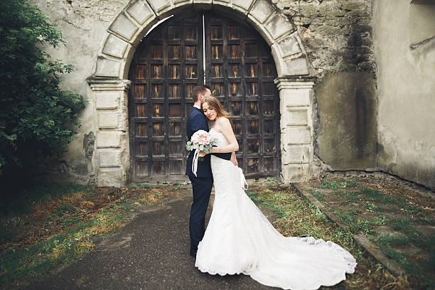 istock Happy wedding couple hugging and smiling each other on background 613792528