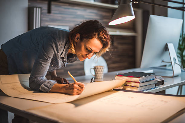 Designing a new real estate Shot of an attractive young architect working in her office. architect stock pictures, royalty-free photos & images