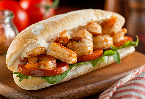 A delicious homemade spicy shrimp sandwich with lettuce, tomato, and tartar sauce.