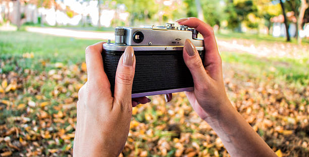 istock retro camera in woman hands 613862446