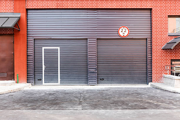 istock modern warehouse building wall with closed metal gate 613862590