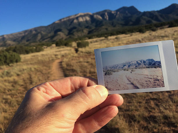 istock hand holding instamatic landscape print within the scene 613865048