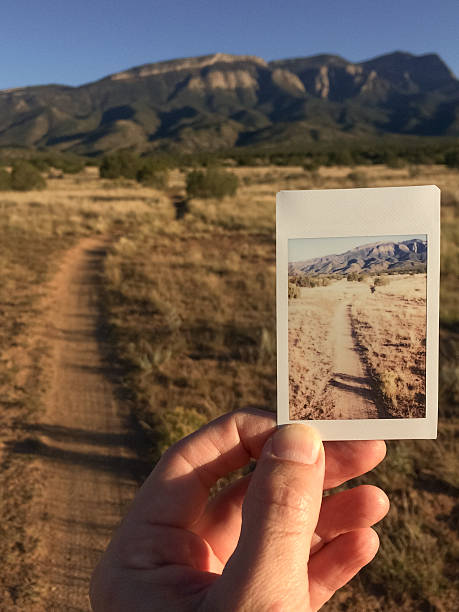 istock hand holding instamatic landscape print within the scene 613865068
