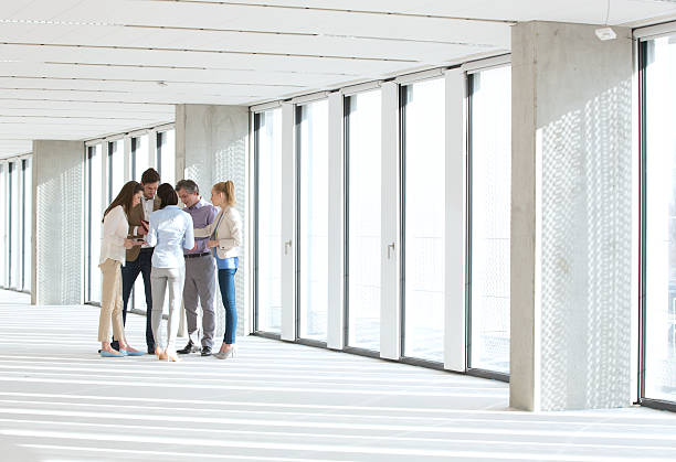 istock Full length of business people having discussion in empty office 613870986