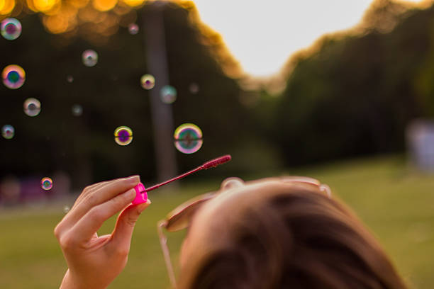 istock Young woman blowing bubbles 613871026