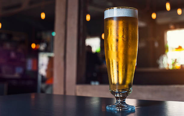 istock Glass of light beer on a pub 613871624
