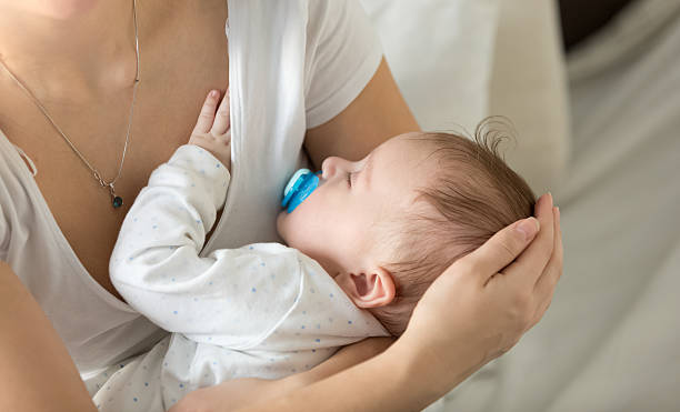 istock Cute 3 months old baby sleeping on mothers hands 613873070