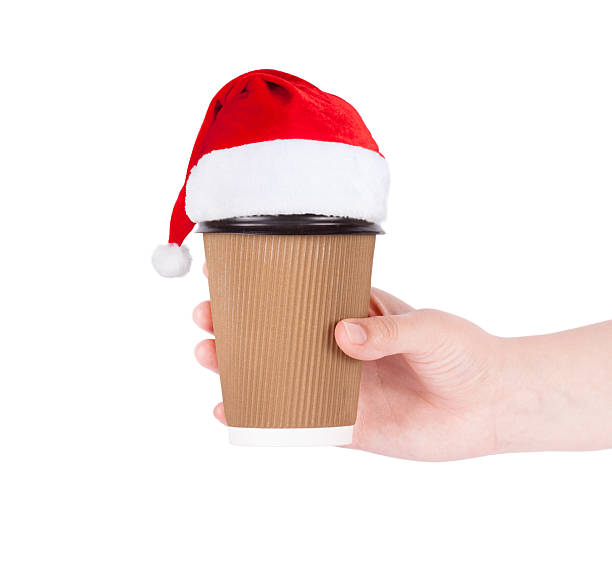 istock disposable cup in santa hat  of coffee in hand 613873266