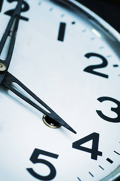 istock Close-up of clock face in cool tone 613873798