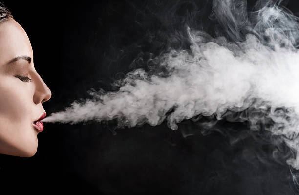 istock Beautiful woman vaping with smoke 613874076