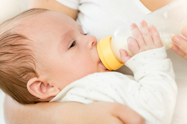istock Cute 3 months old baby boy drinking milk from bottle 613874496