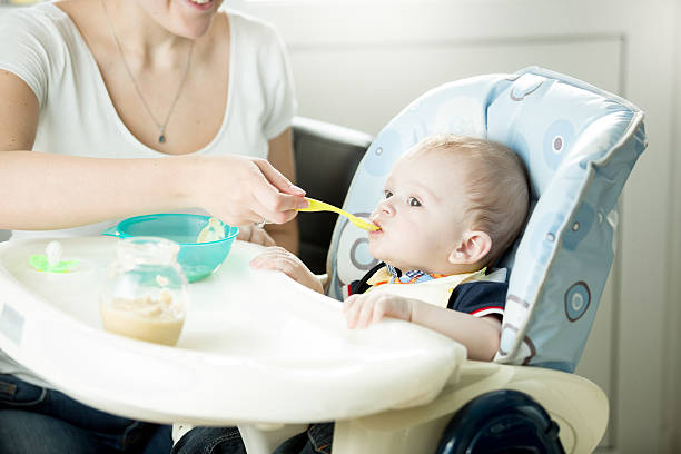 istock Cute 9 month baby boy eating from spoon 613876510