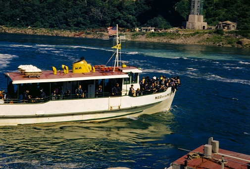 Niagara Falls, United States - January 1, 1960: Tourists crowd the bow of the Maid of the Mist on a tour of Niagara Falls, New York, 1960