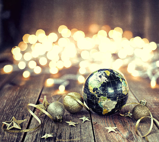 istock Environmentally Friendly Christmas Decorations and Globe on Old Wood Background 613877106