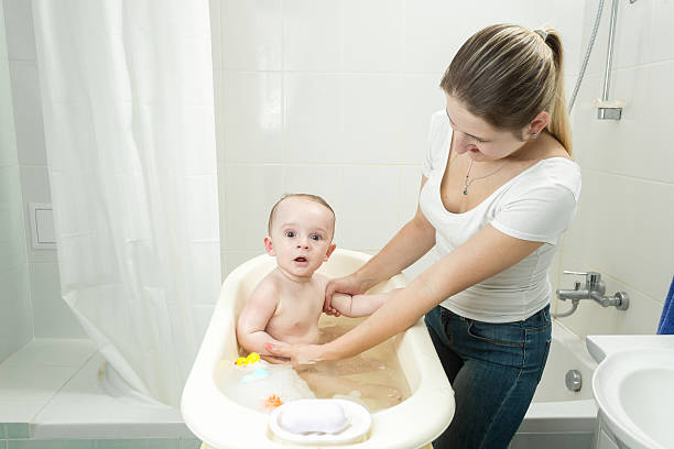istock Young mother washing her baby in bath 613877534