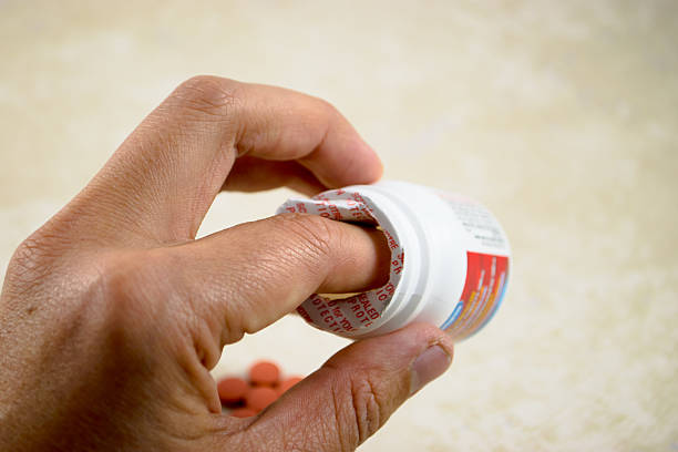 sello que rompe la mano - opening bottle pill bottle pill fotografías e imágenes de stock